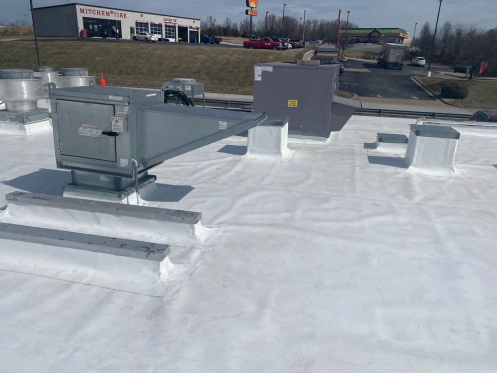 Rooftop HVAC units and vents on a commercial building, clear sky in the background.